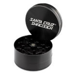 Black Santa Cruz Shredder large 3-piece grinder open with branded lid and visible teeth.