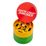 Rasta Santa Cruz Shredder 3-Piece Grinder Small open with red lid, yellow teeth and green body