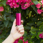 DaVinci MIQRO-C Vaporizer in pink being held beside flowers.