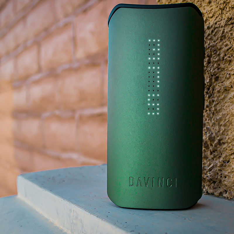Green DaVinci IQC Vaporizer standing next to wall