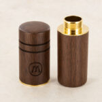 Marley Natural small wooden holder with gold metal threading, shown open beside its matching closed walnut cap on a light studio background.