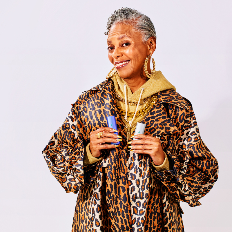 Woman holding PAX Plus and PAX Mini in leopard top
