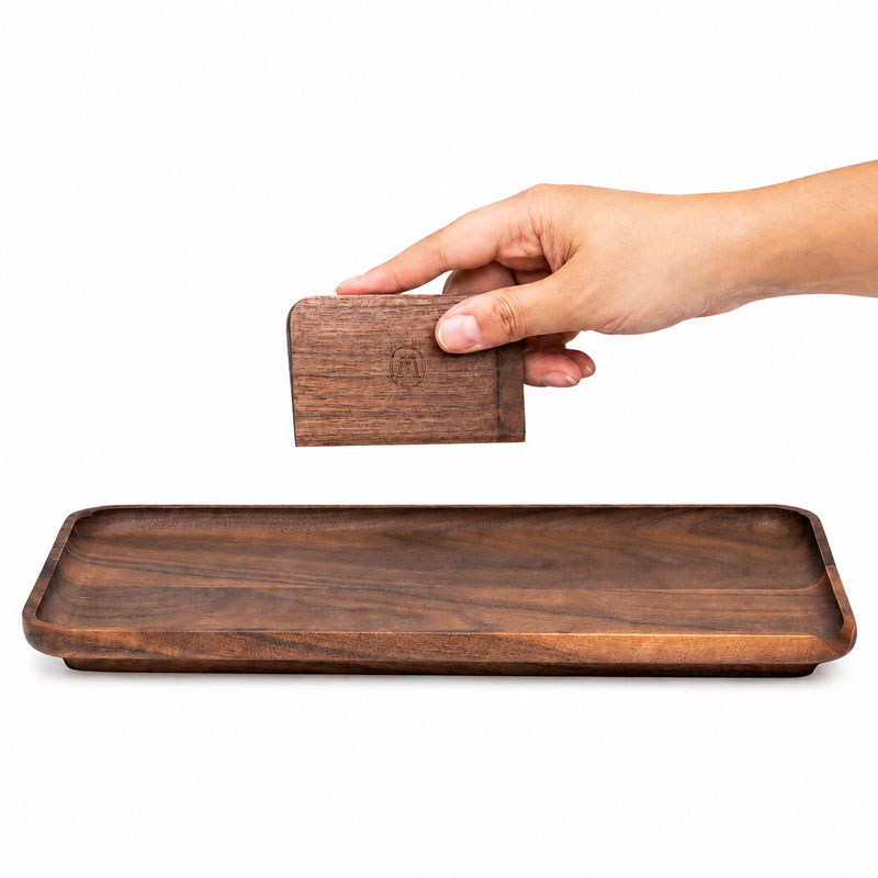 Hand holding a wooden scraper over a Marley Natural walnut rolling tray