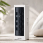 PAX Flow Grip Sleeve retail box with black grip sleeve on a neutral lifestyle background.