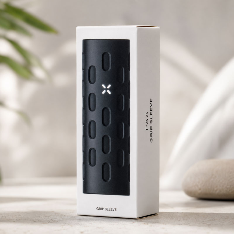 PAX Flow Grip Sleeve retail box with black grip sleeve on a neutral lifestyle background.