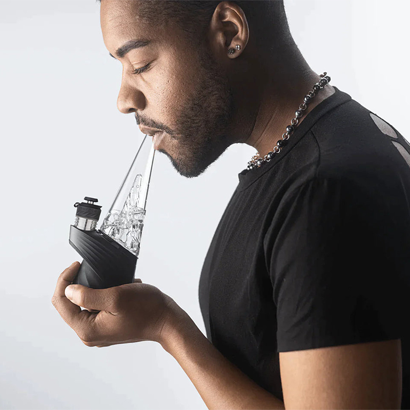 Lifestyle photo of person using Puffco Peak Pro indoors