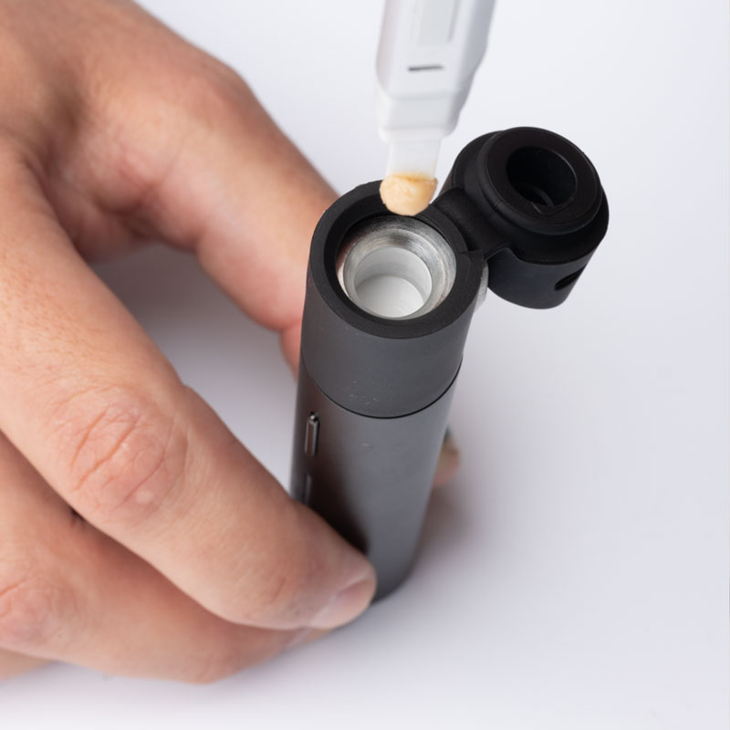 Puffco Hot Knife loading concentrate into the open chamber of the Puffco Pivot vaporizer.