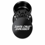 Black Santa Cruz Shredder 3-piece grinder shown open, displaying the logo lid, grinding section and chamber.