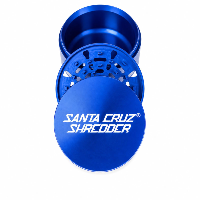 Blue Santa Cruz Shredder 3-piece grinder opened to show the lid, grinding teeth and chamber on a white background.