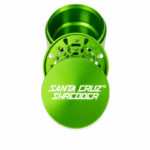 Green Santa Cruz Shredder 3-piece grinder opened to show the lid, teeth and storage chamber on a white background.