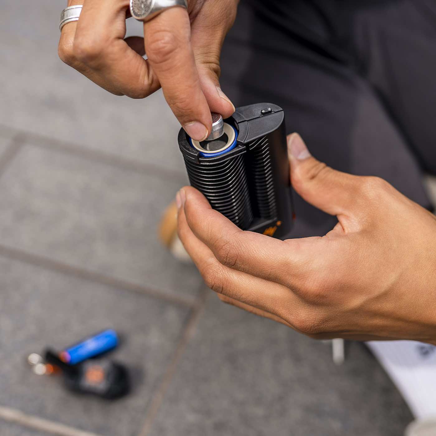 Crafty+ dry herb vape being loaded by hand outdoors