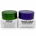 Santa Cruz Shredder 2-piece large grinders in green and purple on branded boxes.