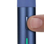 Finger adjusting the control button on the Puffco Pivot sapphire portable vaporizer with LED light indicator active.