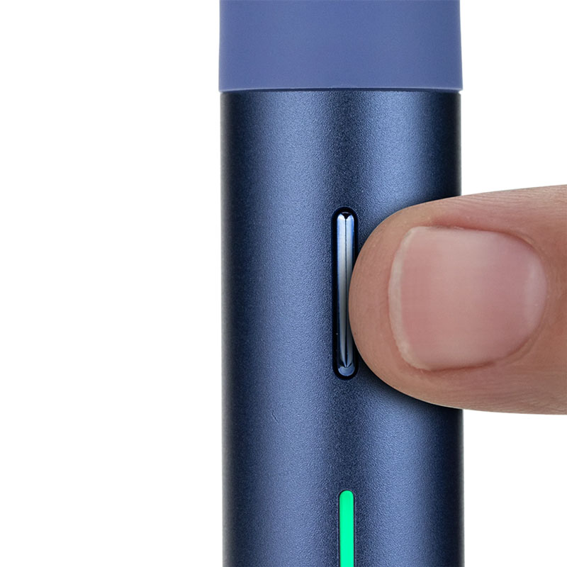 Finger adjusting the control button on the Puffco Pivot sapphire portable vaporizer with LED light indicator active.