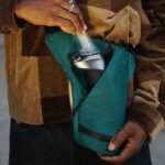close up of person packing gear into travel bag