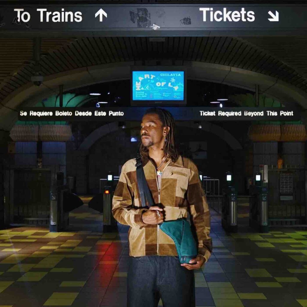 man travelling through train station with bag