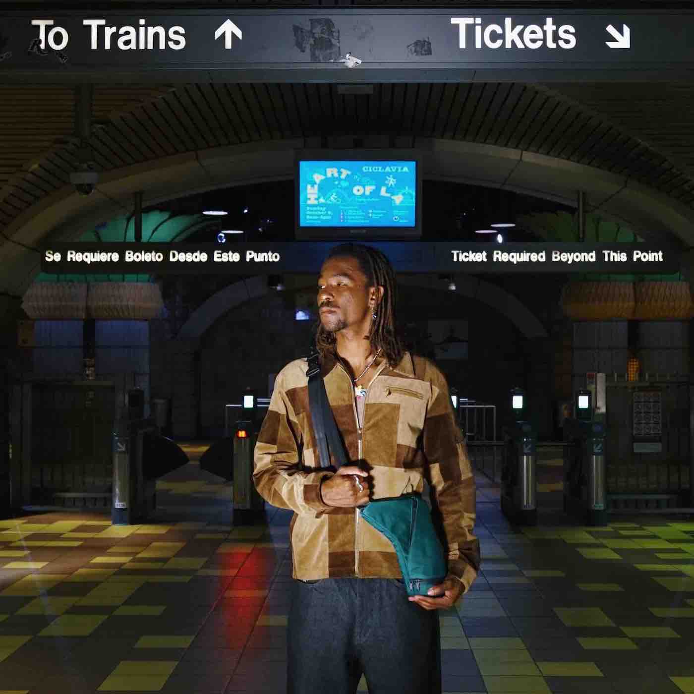 man travelling through train station with bag