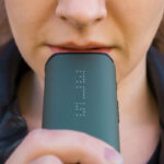 Person using the green DaVinci IQC Vaporizer