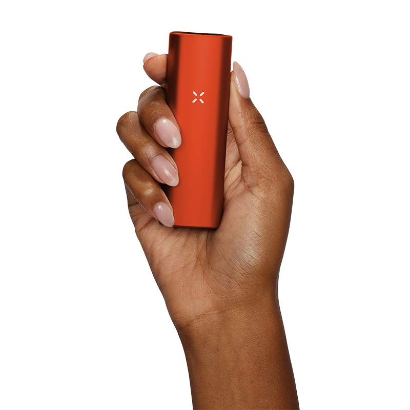 Person holding PAX Mini in Poppy finish