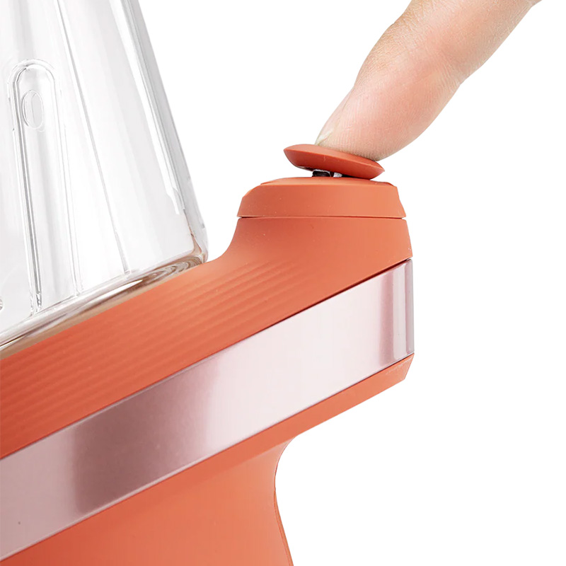 Close-up of Puffco Peak Sunset orange power button and texture