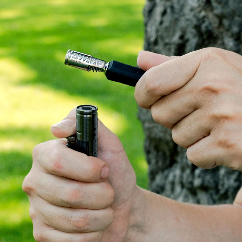 DynaVap The B2 vaporizer held outdoors against a green background