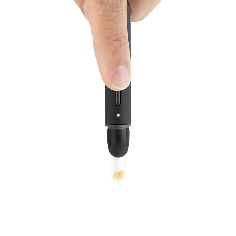 Close view of a hand pressing the Puffco Hot Knife 2.0 while concentrate sits on the tip