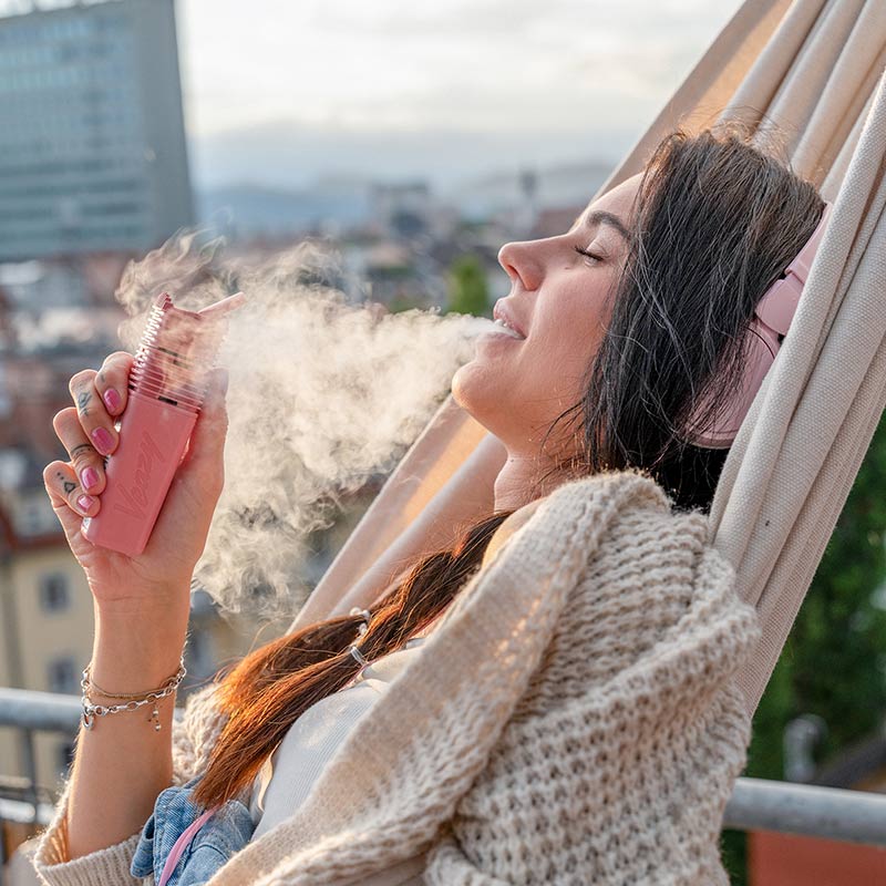 a woman relaxing vaping on a hammock