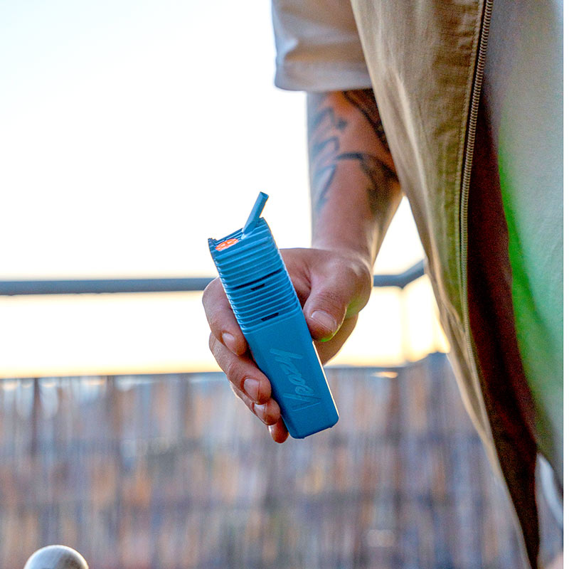 man holding blue vape outside