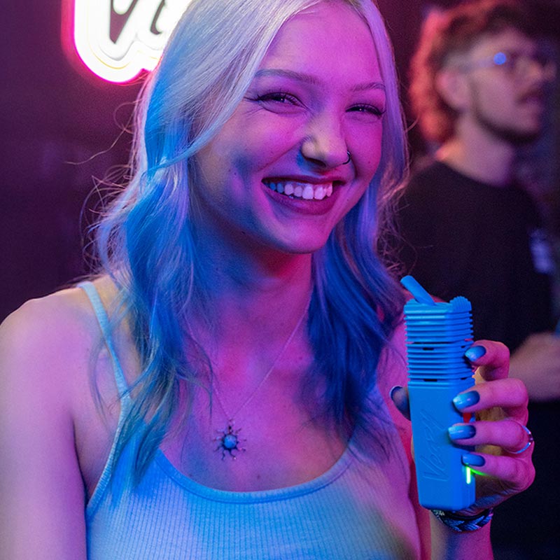 blonde woman laughing in a bar holding the veazy