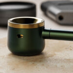 Close-up lifestyle image of Evergreen pipe resting on a stone surface