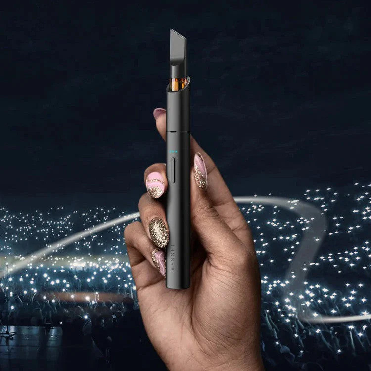 Hand holding Vessel Vista Edge 510 battery against dark atmospheric backdrop.