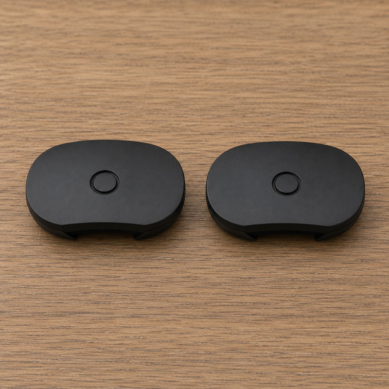 Two black flat mouthpieces on a wooden surface