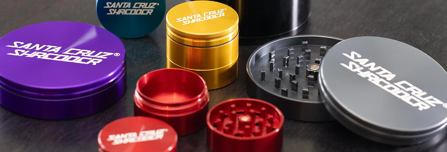 Santa Cruz Shredder herb grinders in multiple colours, including assembled and open grinder sections.