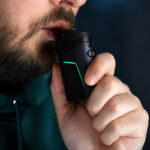 Close-up of a man inhaling from the Dr. Dabber Ghost 2 vaporizer
