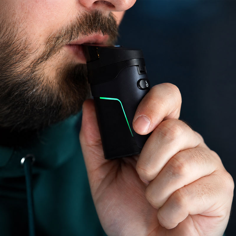 Close-up of a man inhaling from the Dr. Dabber Ghost 2 vaporizer