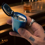 Blue DaVinci IQ Core vaporizer held in a hand with the top lid open