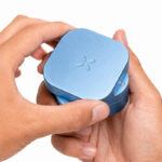 PAX Grinder in Blue Haze held in both hands showing the rotating top section
