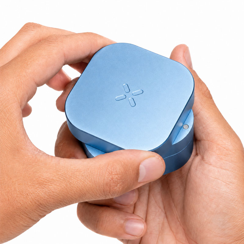 PAX Grinder in Blue Haze held in both hands showing the rotating top section