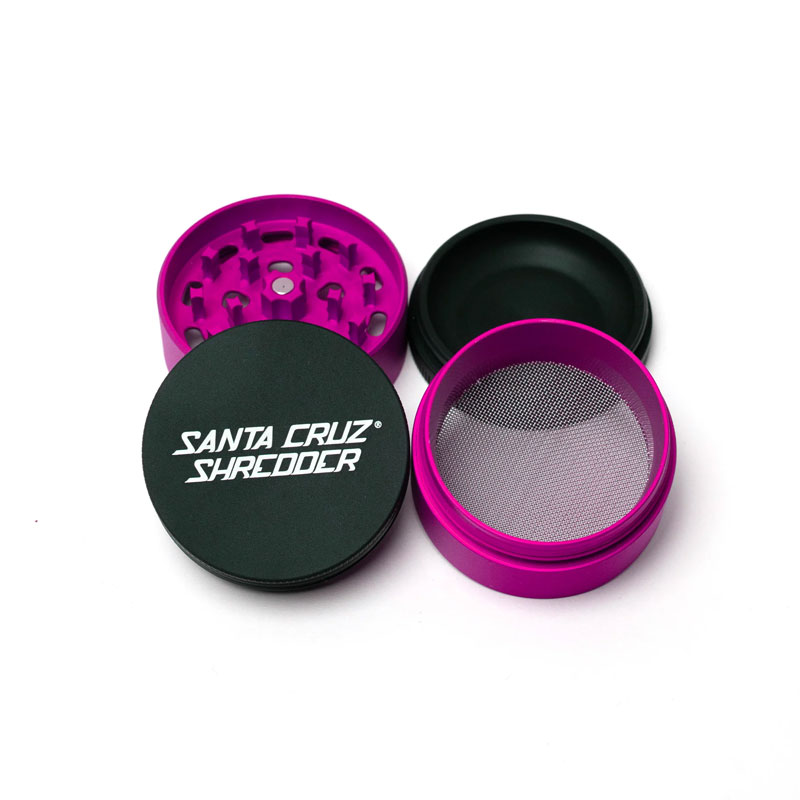 Santa Cruz Shredder Split Series pink and black grinder opened to show the teeth, screen and collection chamber