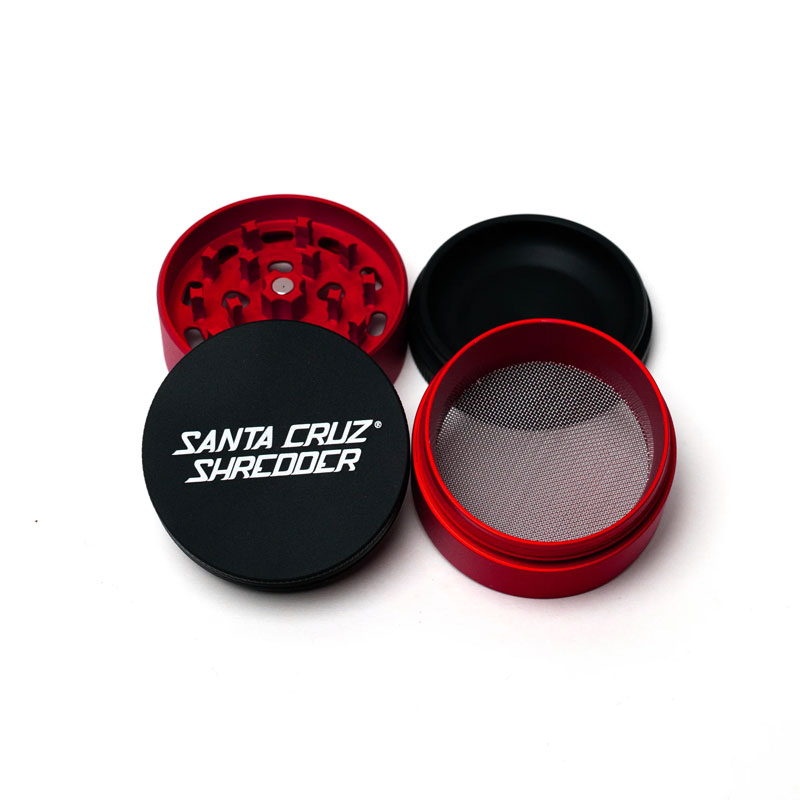 Santa Cruz Shredder Split Series red and black grinder opened to show the teeth, screen and collection chamber