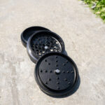 G Pen 3-Piece Slim Grinder separated into three sections outdoors