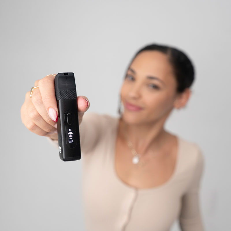 Person holding the G Pen Micro 2 Vaporizer with silicone mouthpiece attached and display visible