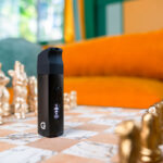 G Pen Micro 2 Vaporizer standing on a chessboard with its curved silicone mouthpiece attached