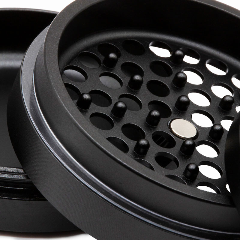 Close up of the G Pen Slim Grinder grinding chamber with pegs, holes and centre magnet