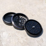Open G Pen 3-Piece Slim Grinder showing the collection chamber, grinding plate and magnetic lid