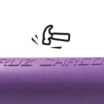 Close-up of purple Santa Cruz Shredder Hemp Dugout showing embossed brand logo and textured hemp composite surface