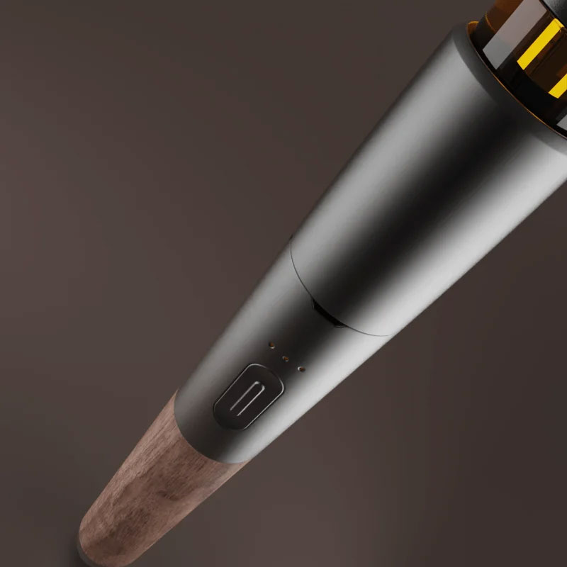 Angled close up of the Vessel Craftsman 510 Battery showing its smooth metal housing, control button and natural walnut grain