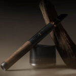 Vessel Craftsman 510 Battery with walnut wood finish displayed beside a Vessel charging base and natural wood