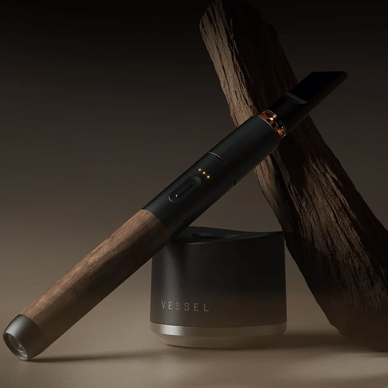 Vessel Craftsman 510 Battery with walnut wood finish displayed beside a Vessel charging base and natural wood